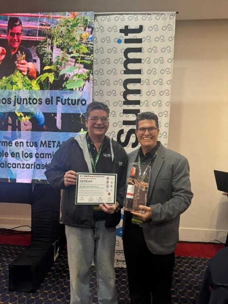 Eduardo Castillo entrega a Alí Olivero su certificado como expositor